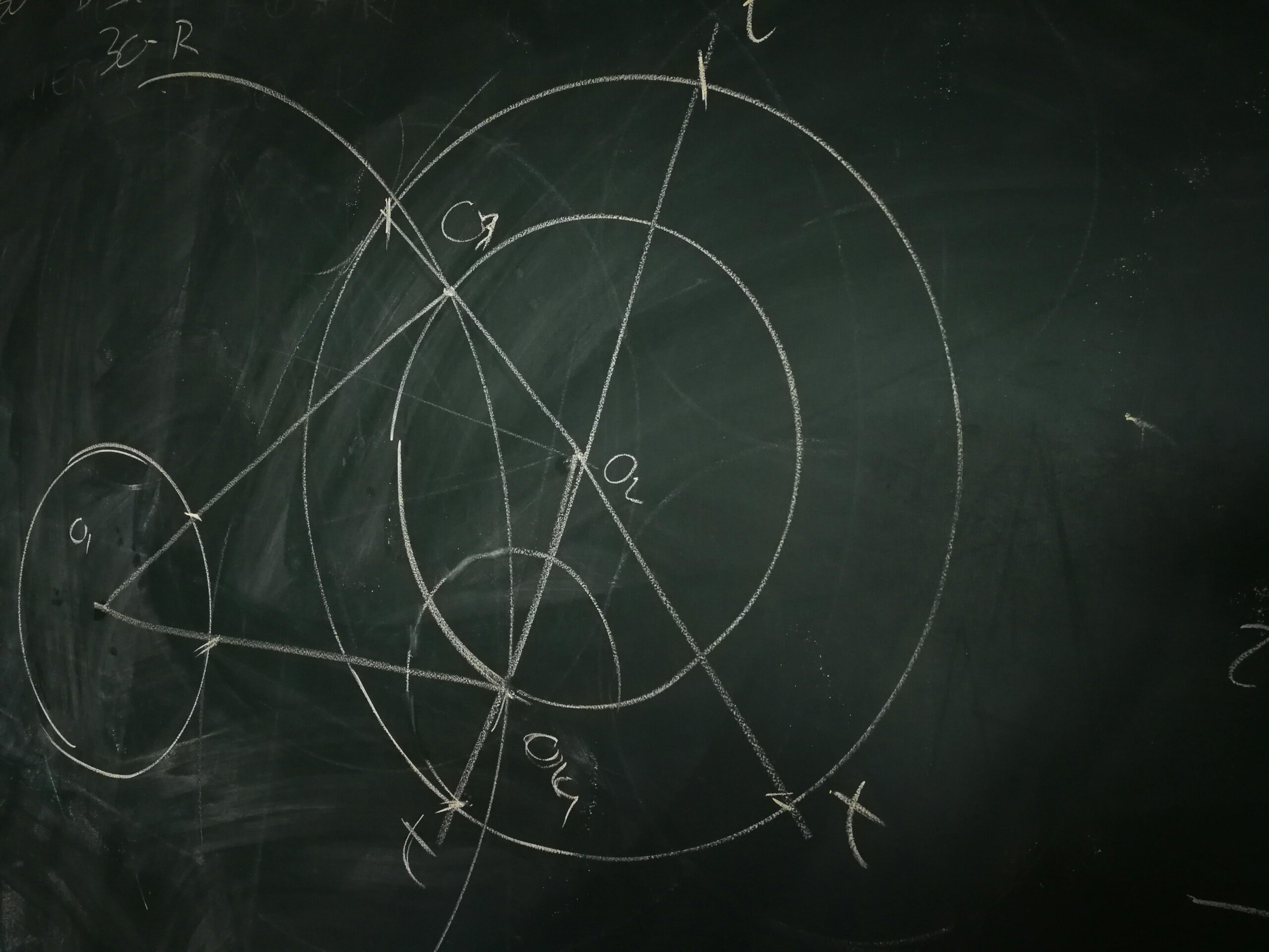 Chalk drawing of geometric shapes and calculations on a blackboard.